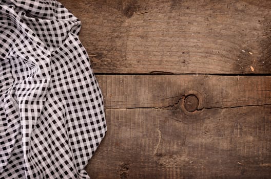 Checkered table cloth on a wooden background with space for text or image