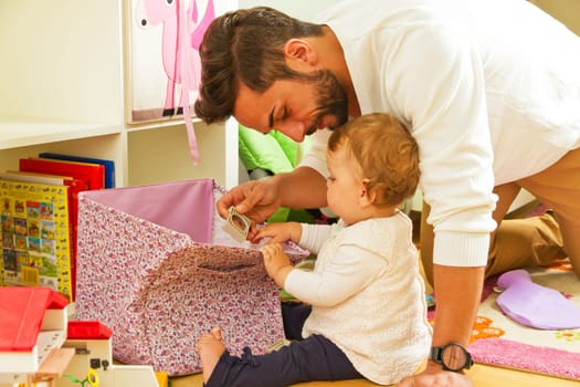 Father with young daughter in the nursery while playing