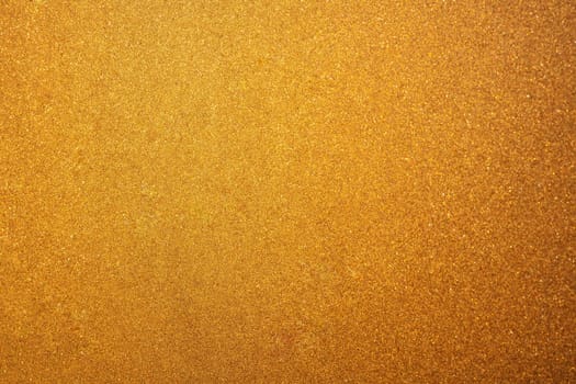 Abstract glittering golden or yellow dust or sand background with blur edges of image