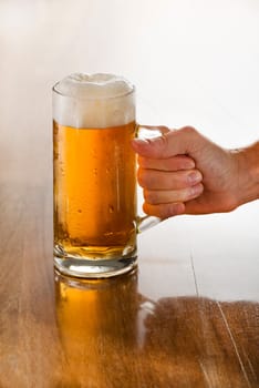 Bartender holding a freshly tapped glass of beer in his hand.