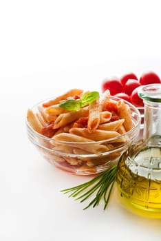 Penne pasta in tomato sauce decorated with basil on a white background.