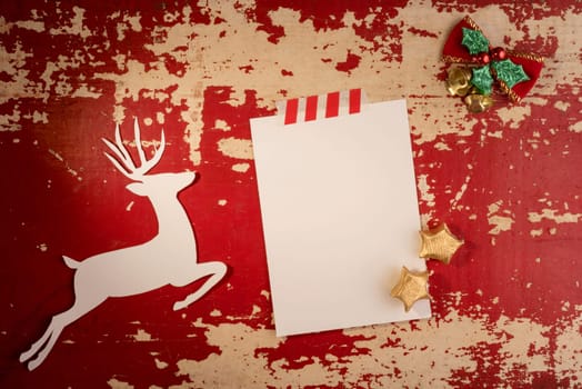Christmas greeting card paper note top view template with deer silhouette and vintage xmas decoration on grunge wood texture background.   .