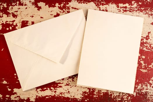 Vintage greeting card top view concept template with paper envelope on grunge wood texture background. Includes clipping path.