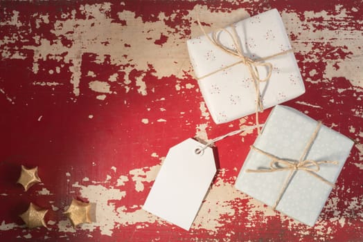 Holiday greeting card concept, top view retro gift boxes with empty label mockup template on grunge texture background. Includes clipping path.