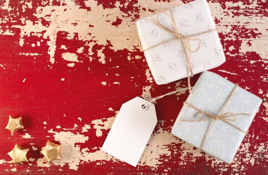 Christmas top view concept label template with vintage gift boxes and decoration on hipster wood texture background. Includes clipping path for tag.