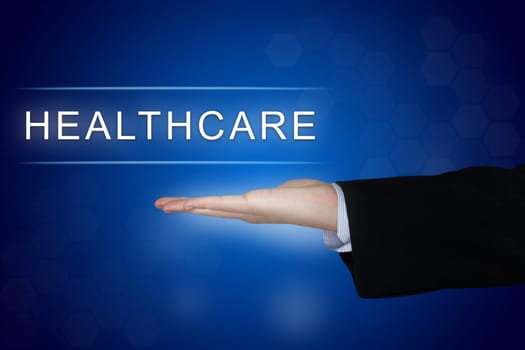 healthcare button with business hand on blue background