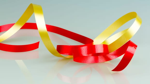 Gold and Red Ribbon String close up on grey/white background.