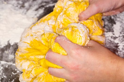 Hands in Saffron Bun Dough close up image.