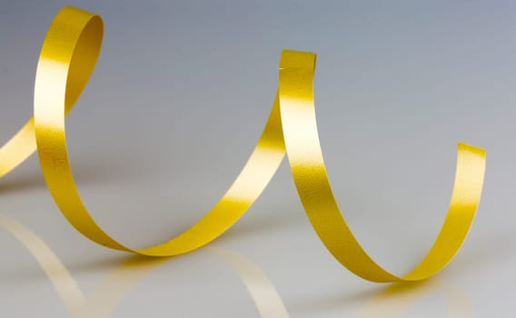 Gold Ribbon String close up on grey/white background.