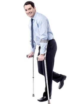 Businessman tying to walk with crutches