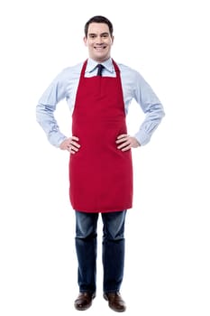 Male executive wearing apron and posing with hands on waist