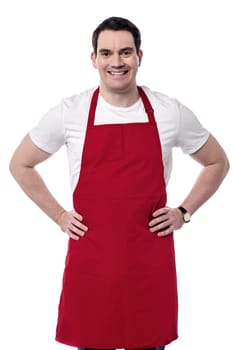 Middle aged chef posing happily against white