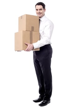 Full length of smiling business man holding pile of boxes