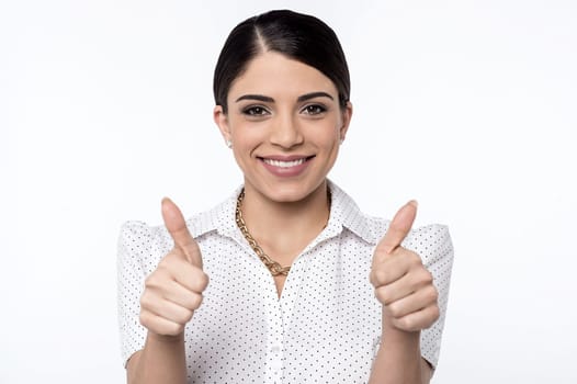 Smiling woman gesturing thumbs up to camera