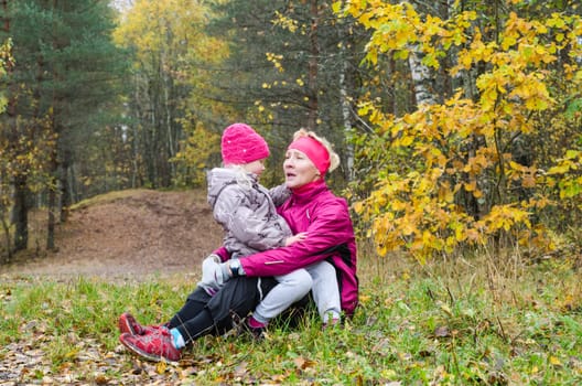 Grandmother with her granddaughter in the autumn park