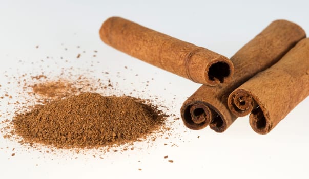 Cinnamon Sticks and Powder close up on white background.