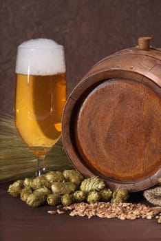 Old wooden barrel with beer glass,wheat,barley,hops and malt