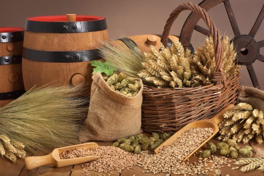 Three beer barrels with wheat,barley,hops and malt