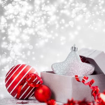 Christmas balls and ornaments in front of glittering background