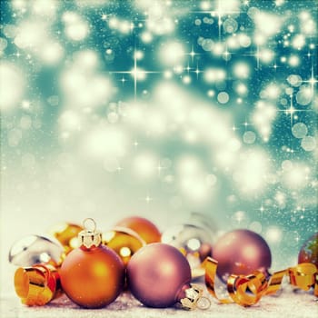 Christmas balls and ornaments in front of glittering background