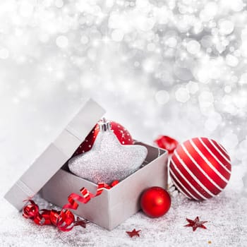 Christmas balls and ornaments in front of glittering background