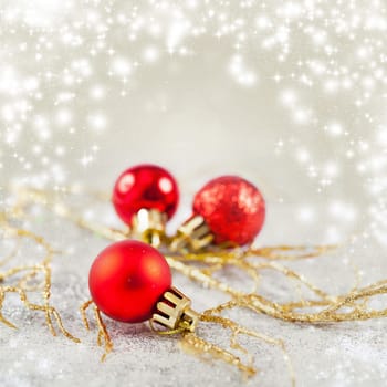 Christmas balls and ornaments in front of glittering background