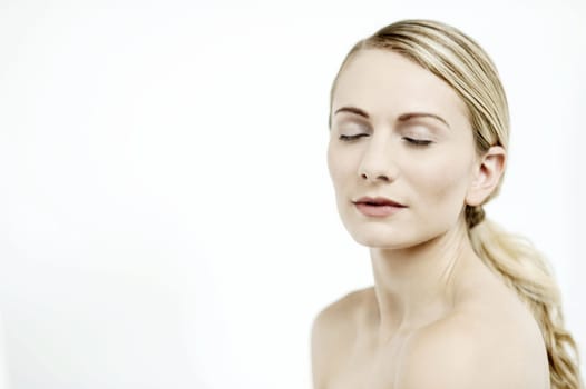 Image of an attractive woman with bare shoulders and closed eyes