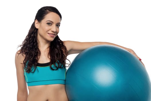 Pretty woman holding swiss ball on her hip