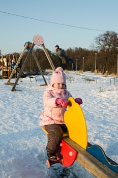 Children swinging on a swing in winter