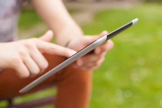Young man read news and communicate on social networks with tablet computer in park