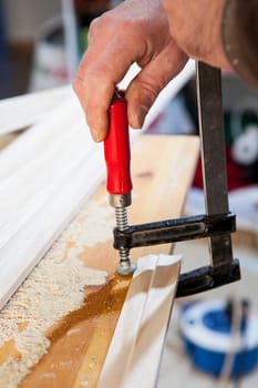 Carpenter working with doorjambs using electric circular saw. He is measuring the cutting area