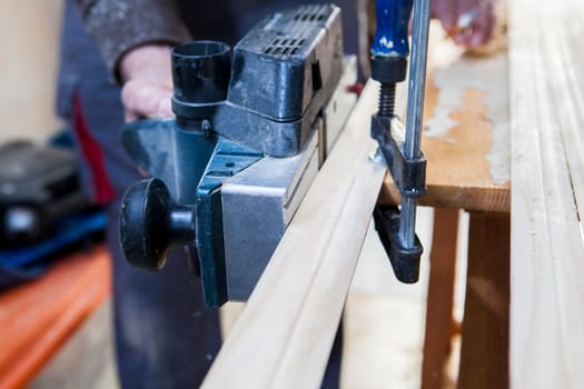 Carpenter working with doorjambs using electric circular saw. He is measuring the cutting area