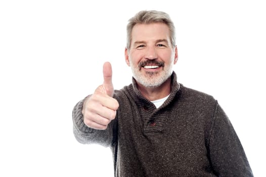 Bearded senior man showing thumbs up sign