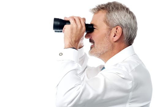 Senior business executive viewing through binocular over white