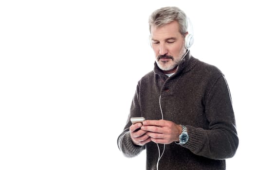 Senior man listening music on his cell phone