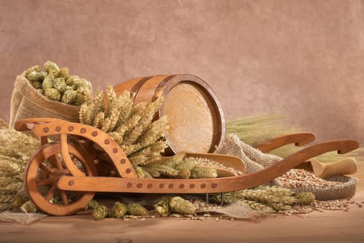 Old barrel with wheelbarrow,wheat,barley,hops and malt