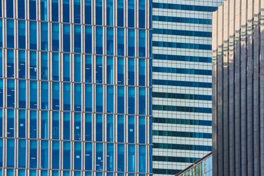 Close up cropped shot of skyscraper window frames in blue metal.
