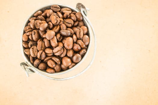 Coffee roasted bean in the bucket on wooden background, stock photo