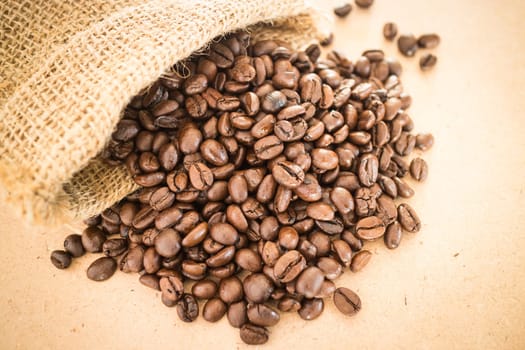 Coffee roasted bean in the sack on wooden background, stock photo