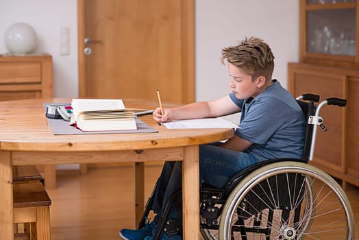 disabled boy in wheelchair doing homework