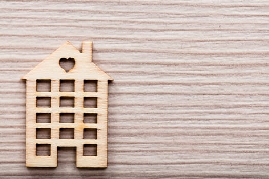 little wooden house with an heart on a wooden background ideal as background or wallpaper
