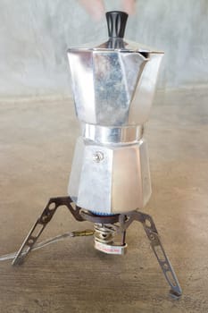 Making coffee with an italian style moka on camping gas stove, stock photo
