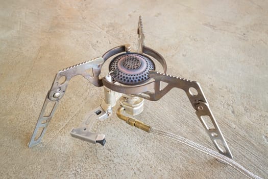 Vintage camping gas stove on grunge floor, stock photo