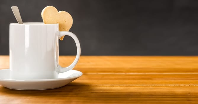 Coffee mug with a heart-shaped biscuit