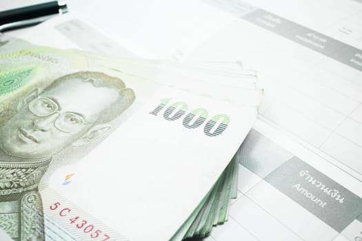 Thai money banknote on record table note book, stock photo