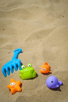funny and colorful plastic toys on the beach