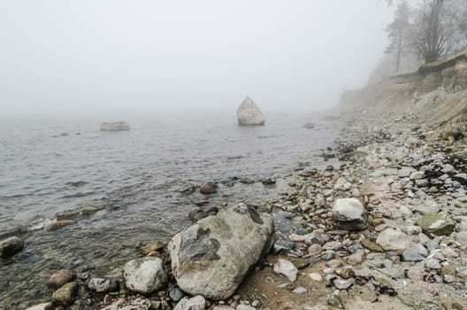 Stony coast of Baltic sea foggy in the morning
