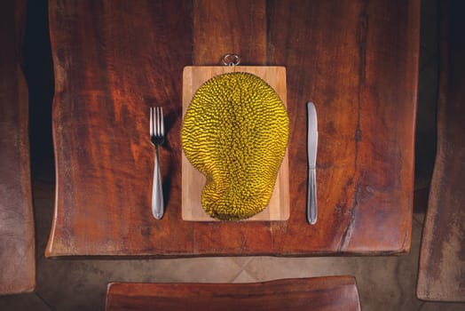 Fruit jackfruit on the table and cutlery around it.