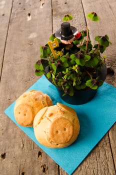 Good luck concept image with pig rolls and clover on a rustic wooden table