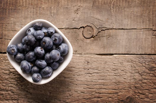 Fresh blueberries on an old rustic table, top view
